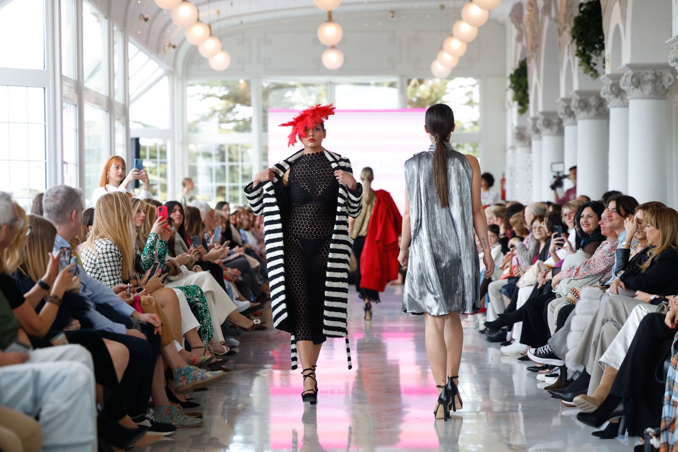 La modelo Abbie Potter con un diseño de Trinidad Castillo, con un llamativo tocado, en color rojo, de la diseñadora Marián Pacheco ('Cocotte').