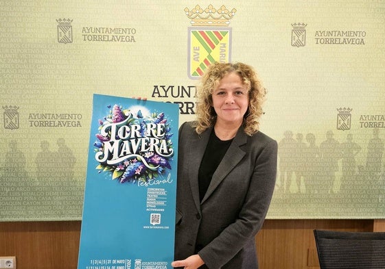 La edil de Festejos, Patricia Portilla, sostiene el cartel del evento, este lunes, en Torrelavega.