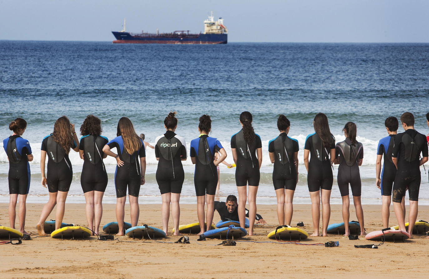 Jóvenes recibiendo clases de surf en la playa de El Sardinero, de Santander.