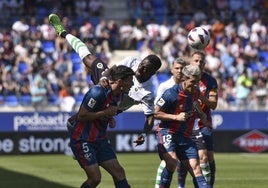 Lago Junior, en pleno salto por hacerse con el balón rodeado por dos jugadores del Huesca.