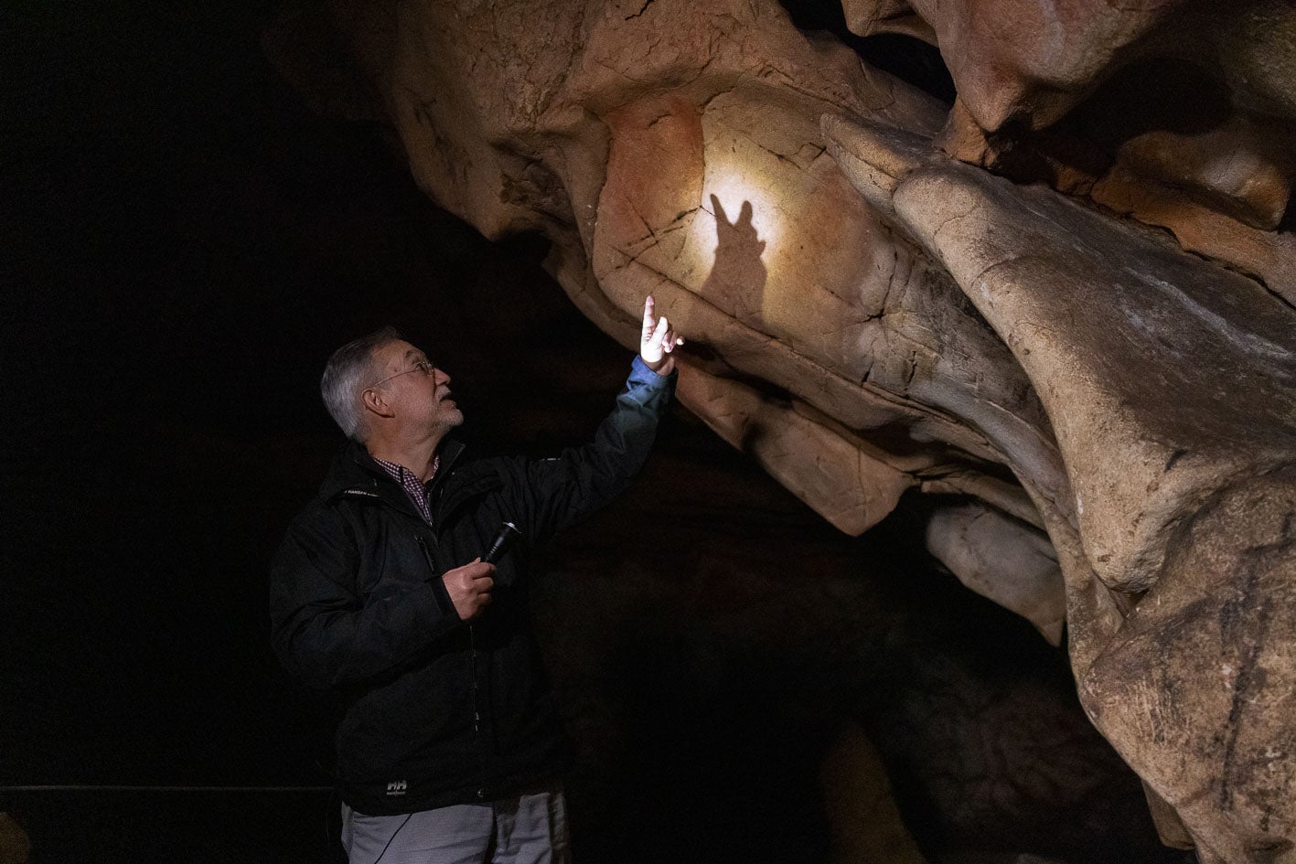 Roberto Ontañón, director de Cuevas Prehistóricas, señala unas manchas en la pared de El Castillo.