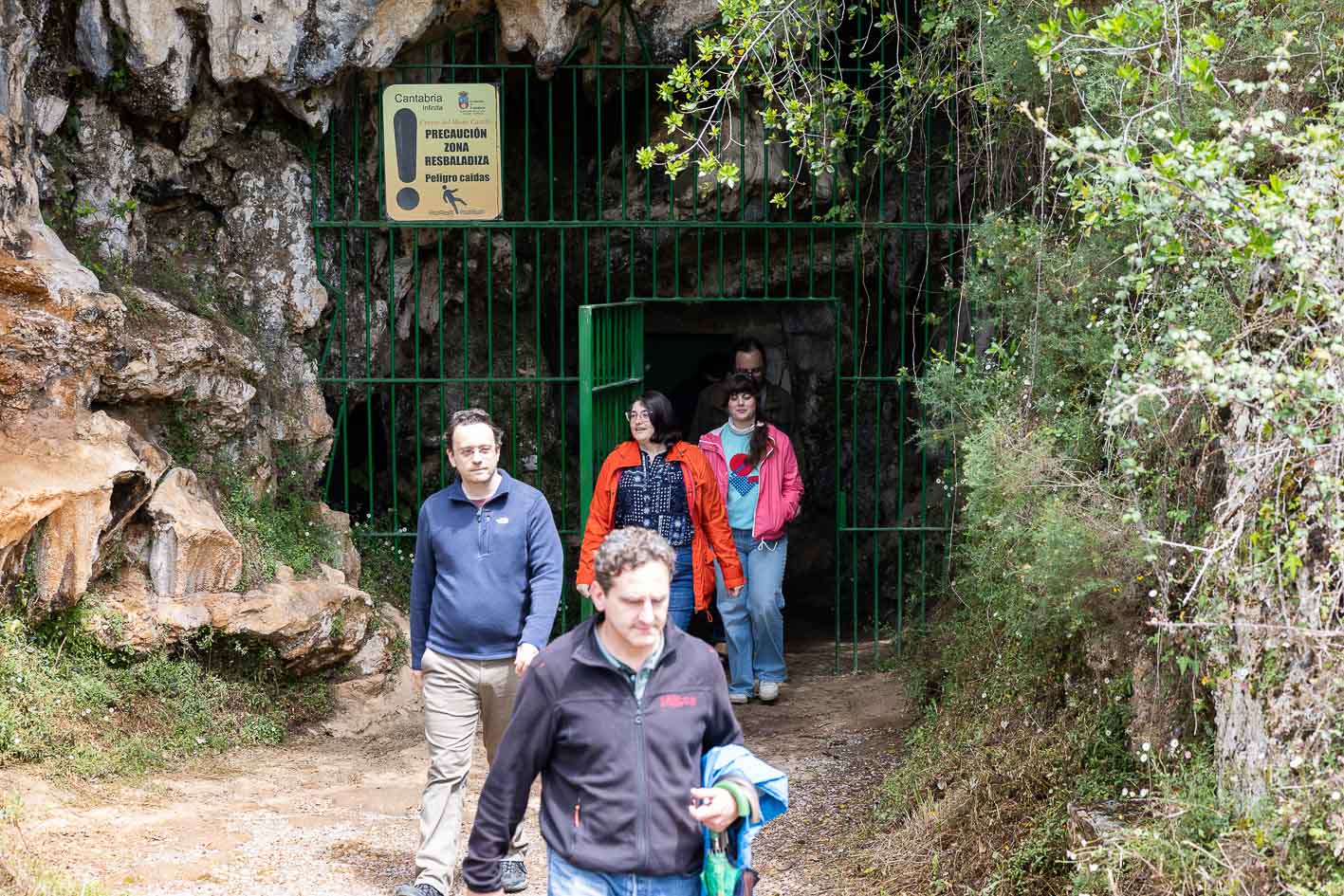 Un grupo de visitantes sale de la cueva de Las Monedas.