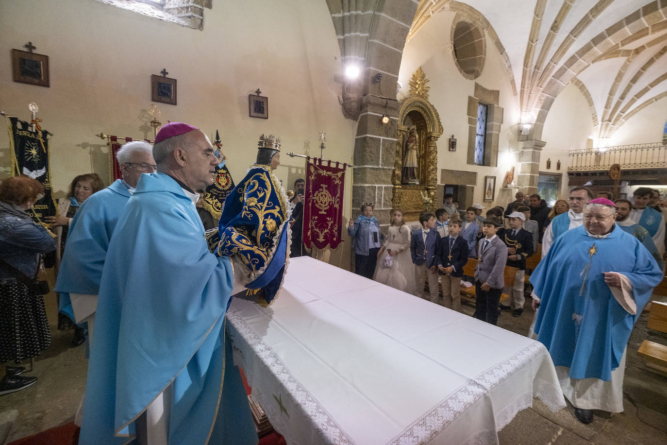 El obispo, Arturo Ros, con la Virgen del Mar sobre el altar, preside la comunión de varios niños.