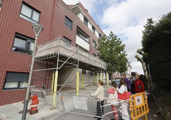 Un grupo de vecinos, ante uno de los edificios de viviendas de Requejada.