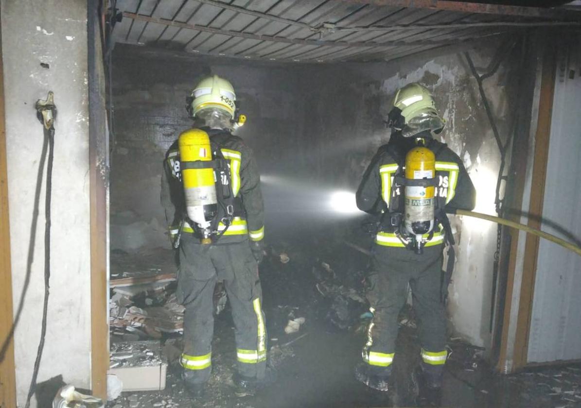 Los bomberos intervienen en el interior del garaje incendiado, totalmente calcinado.