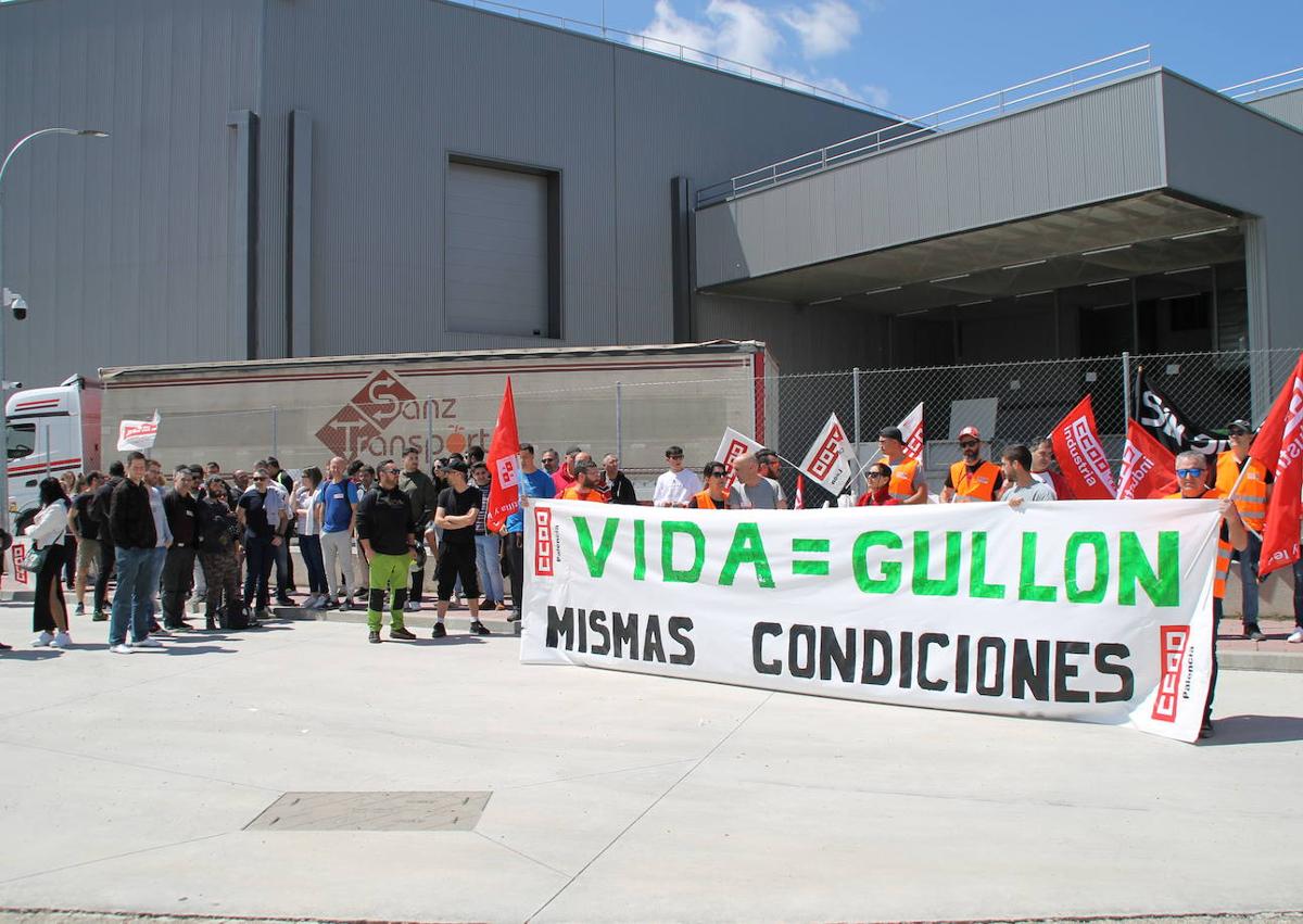 Imagen secundaria 1 - A la izquierda, los trabajadores concentrados en la puerta de la fábrica. A la derecha, una pancarta reivindicativa.