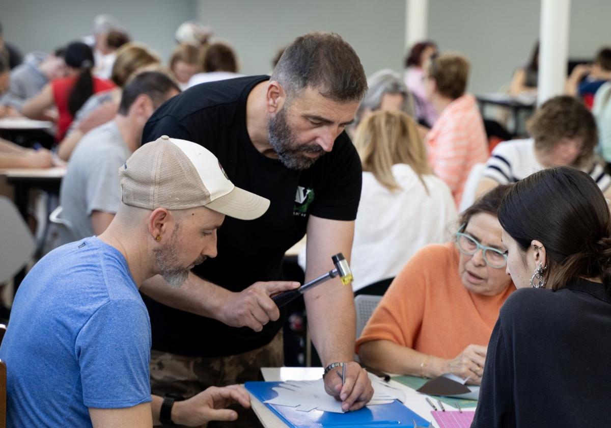 Bernardino Fernández Casas, recreador histórico, instruye a los participantes en el taller de calzado de época.