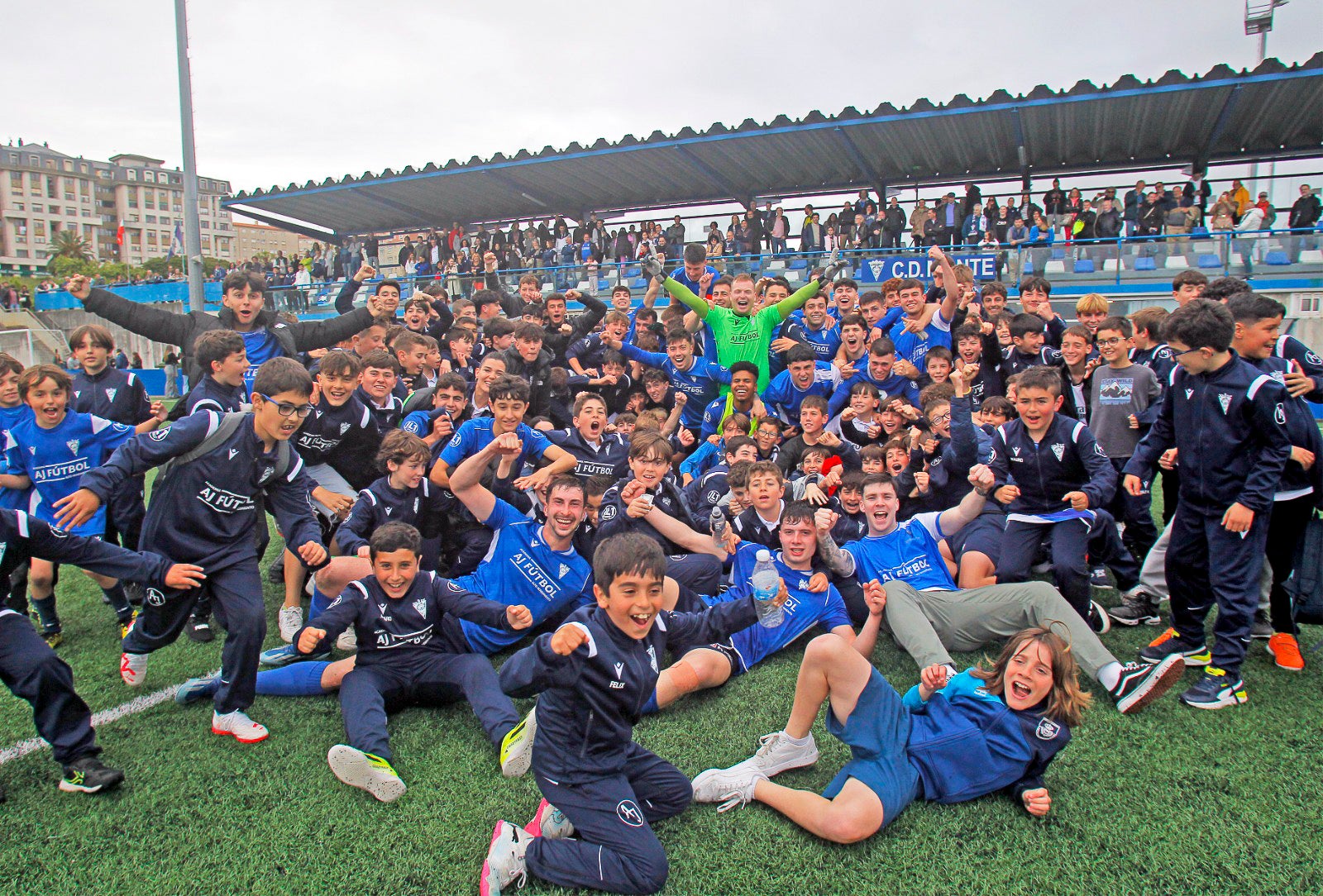 Los jugadores del Monte celebran su ascenso a Tercera RFEF junto a los chicos de la cantera