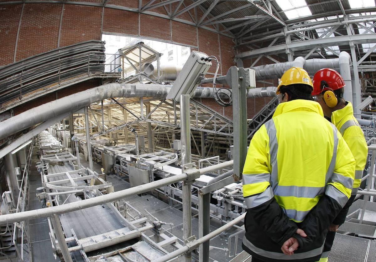 Dos operarios durante su jornada de trabajo en las instalaciones del complejo de Torrelavega.