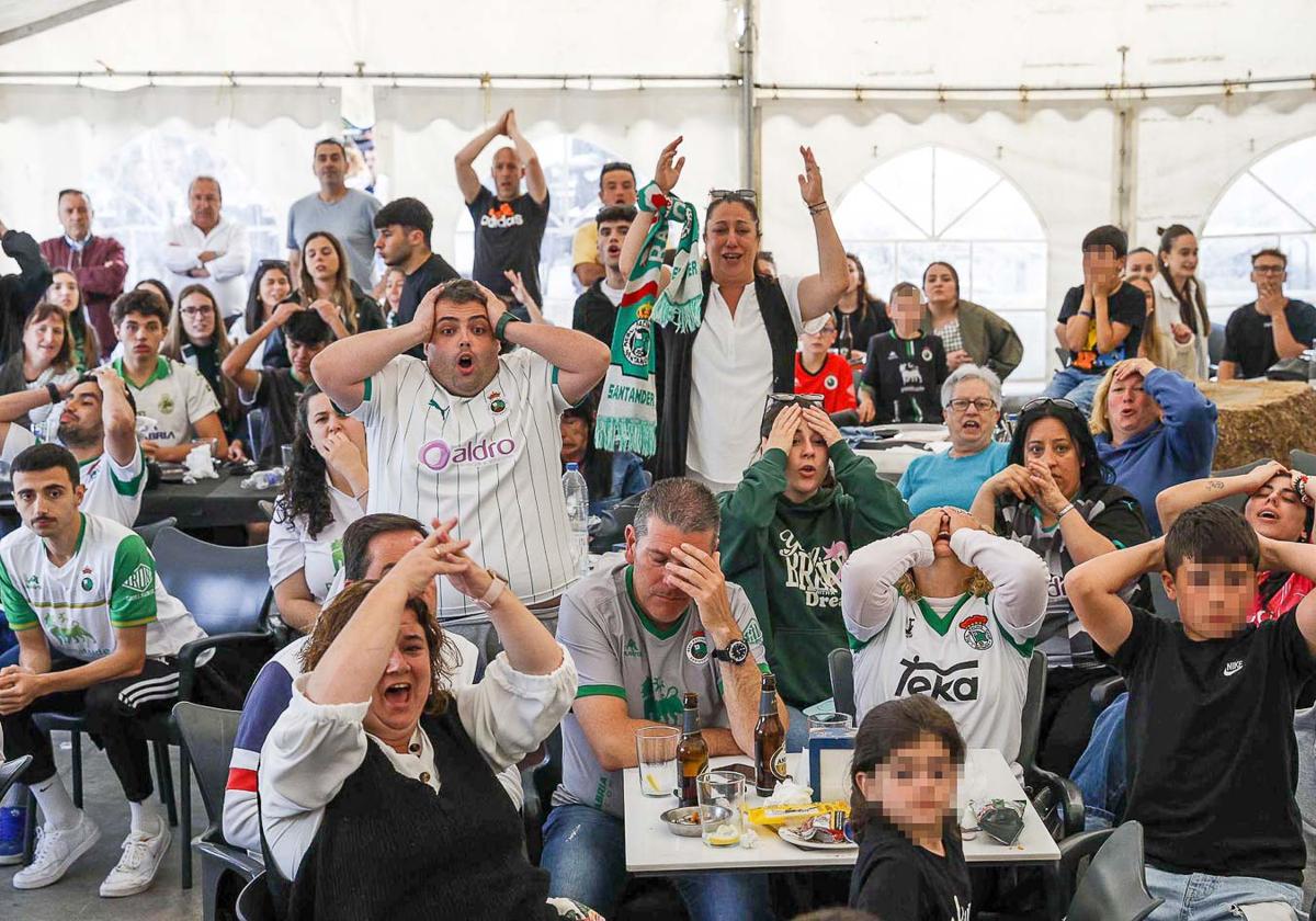 La afición racinguista congregada en la terraza del Navajeda se lamenta y se lleva las manos a la cabeza por un lance del partido