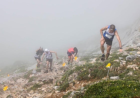 Varios participantes, en pleno esfuerzo entre la niebla en el Kilómetro Vertical de Fuente Dé.