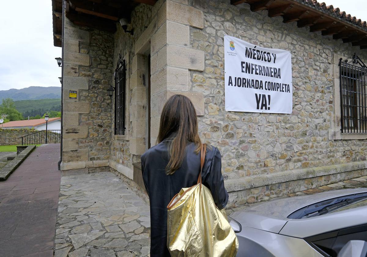 Una pancarta en la que se pide personal sanitario a jornada completa cuelga de la fachada del consultorio de Ruente.