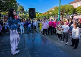 Una joven canta durante la fiesta de Amica en la plaza del barrio San Gil.