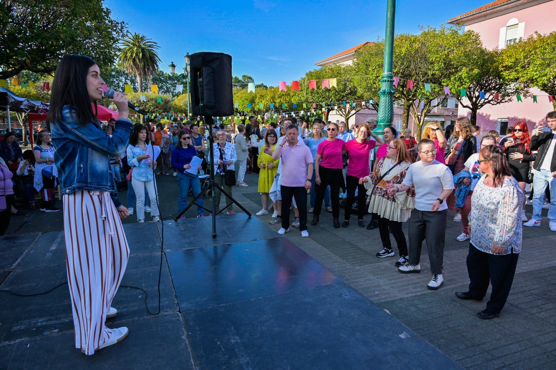 Una joven canta durante la fiesta de Amica en la plaza del barrio San Gil.