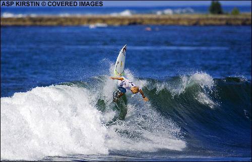 El surfista en una maniobra en la ola.