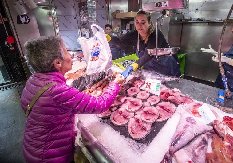 Una clienta comprando en el Mercado de la Esperanza los primeros bonitos de la campaña.