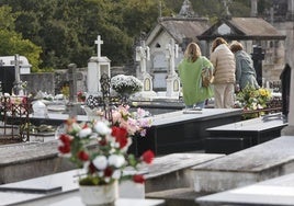 Tres mujeres lloran a un ser querido en un cementerio.