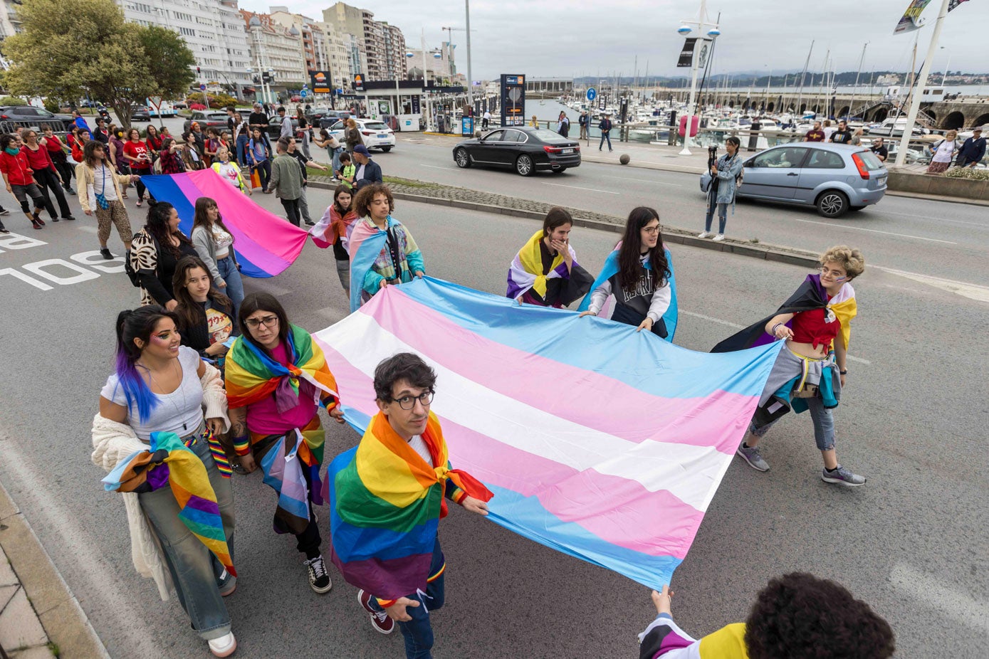 Grupo de jóvenes porta la bandera transgénero.