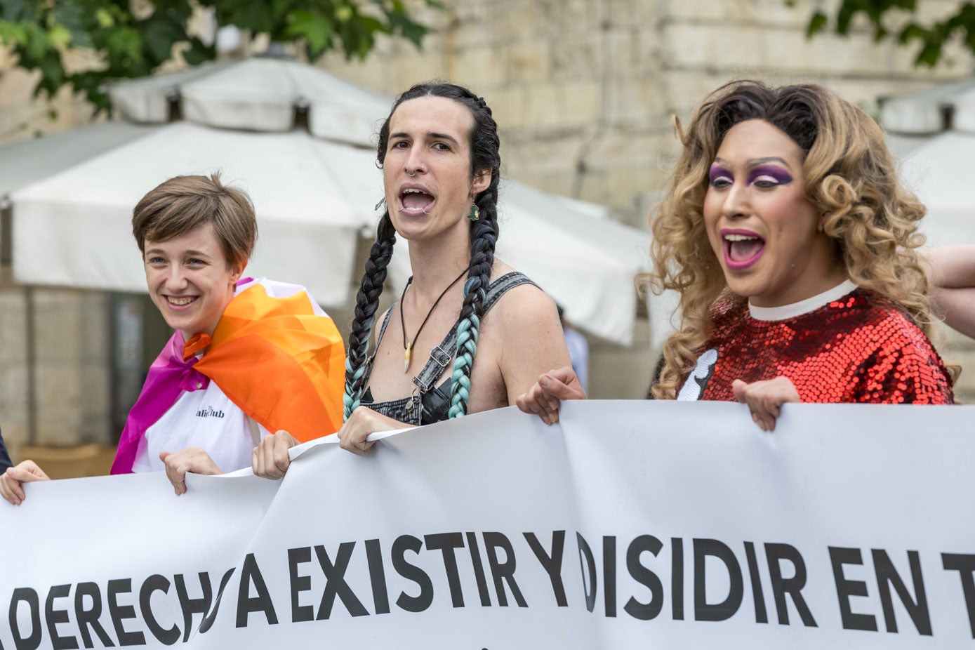 Tres asistentes agarran una gran pancarta durante la manifestación.