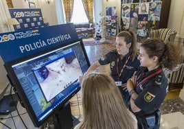 Dos agentes, ante el panel instalado con motivo del encuentro de la Policía Nacional en la UIMP.