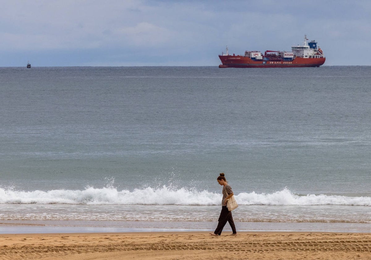 Una mujer pasea por la playa en Santander. La escena es de este lunes.