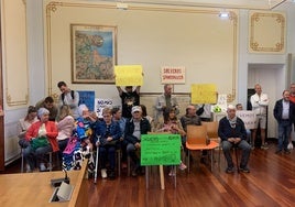 Los vecinos afectados acudieron a la sesión con pancartas de protesta.