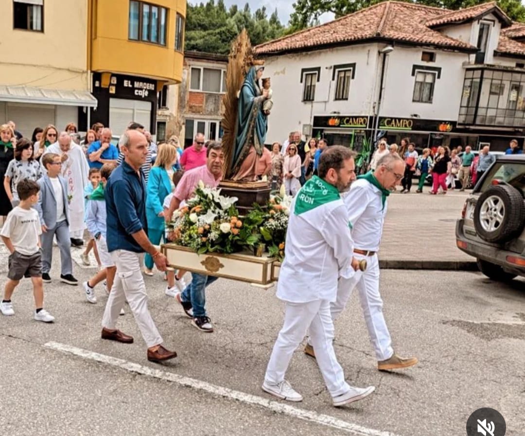 Miembros de la comisión de fiestas y de la Junta Vecinal portando la imagen de la patrona en procesión. 