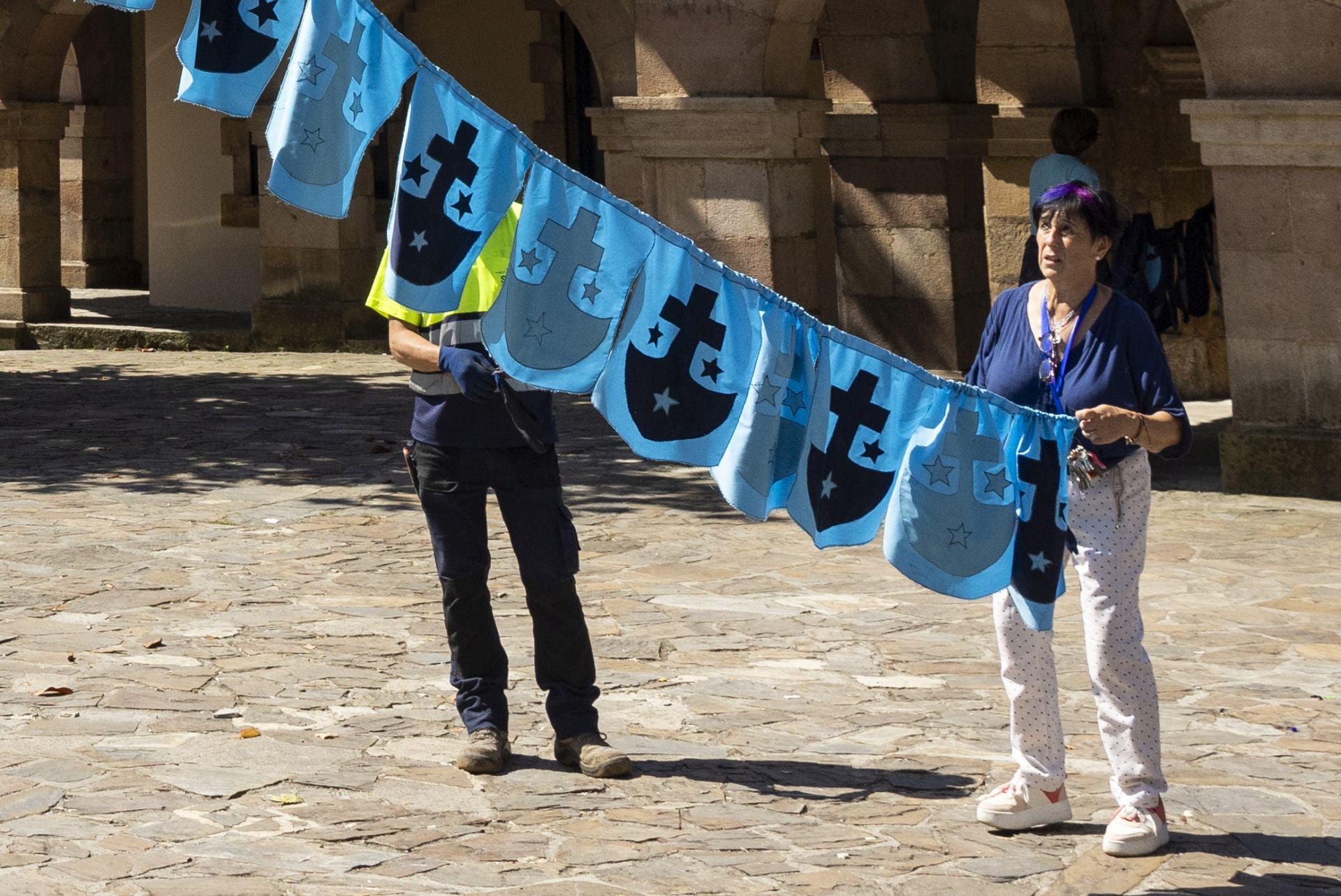 Raquel Cuerno coloca los banderines para adornar las fiestas.