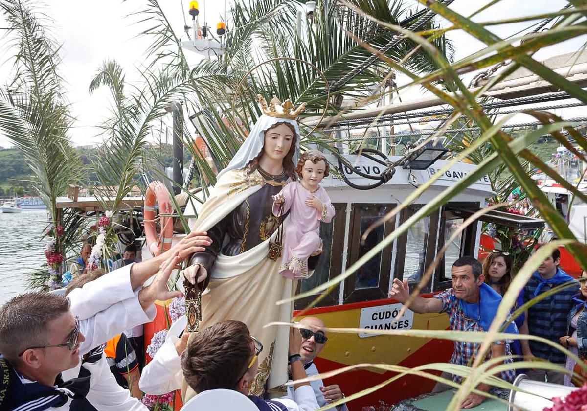 La imagen de la virgen del Carmen en el momento de subirla al barco.