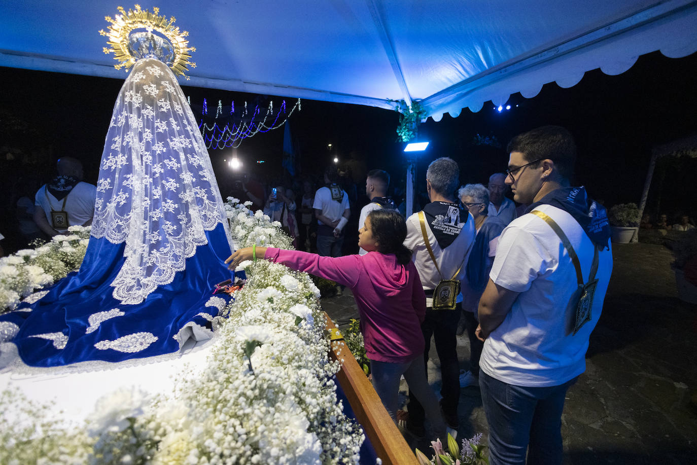 Una joven toca el manto de la Virgen, uno de los gestos más repetidos tras la celebración religiosa. 