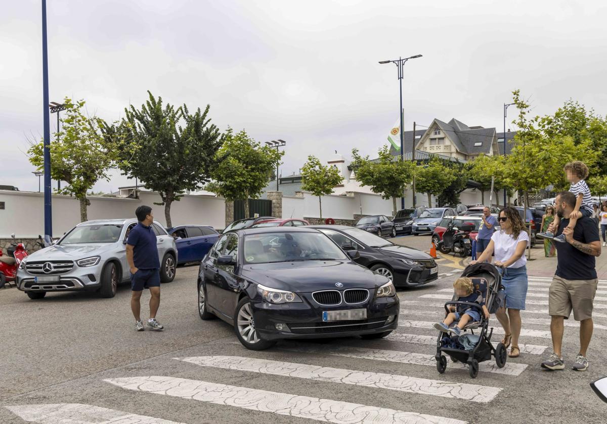 Varios coches circulan por la calle de acceso a la península de La Magdalena y al aparcamiento de la playa de El Camello