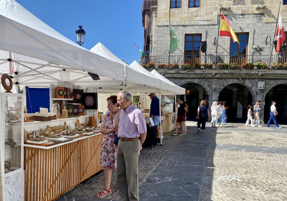 Algunos curiosos visitan los puestos del mercado.