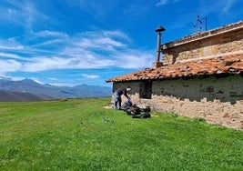 Un senderista se prepara para comer en la braña de El Moral, junto a la ermita