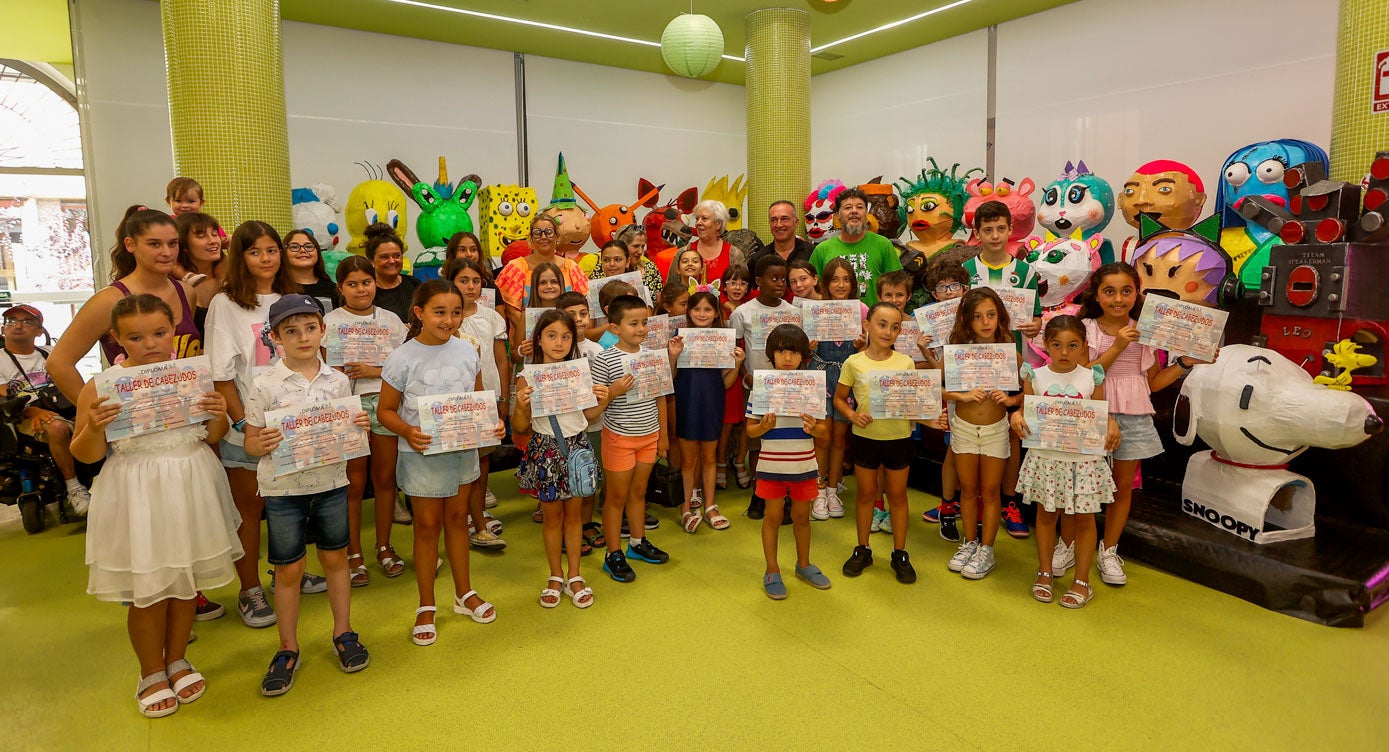 Foto de familia con los niños, sus diplomas, así como familiares y concejales de la Corporación. 