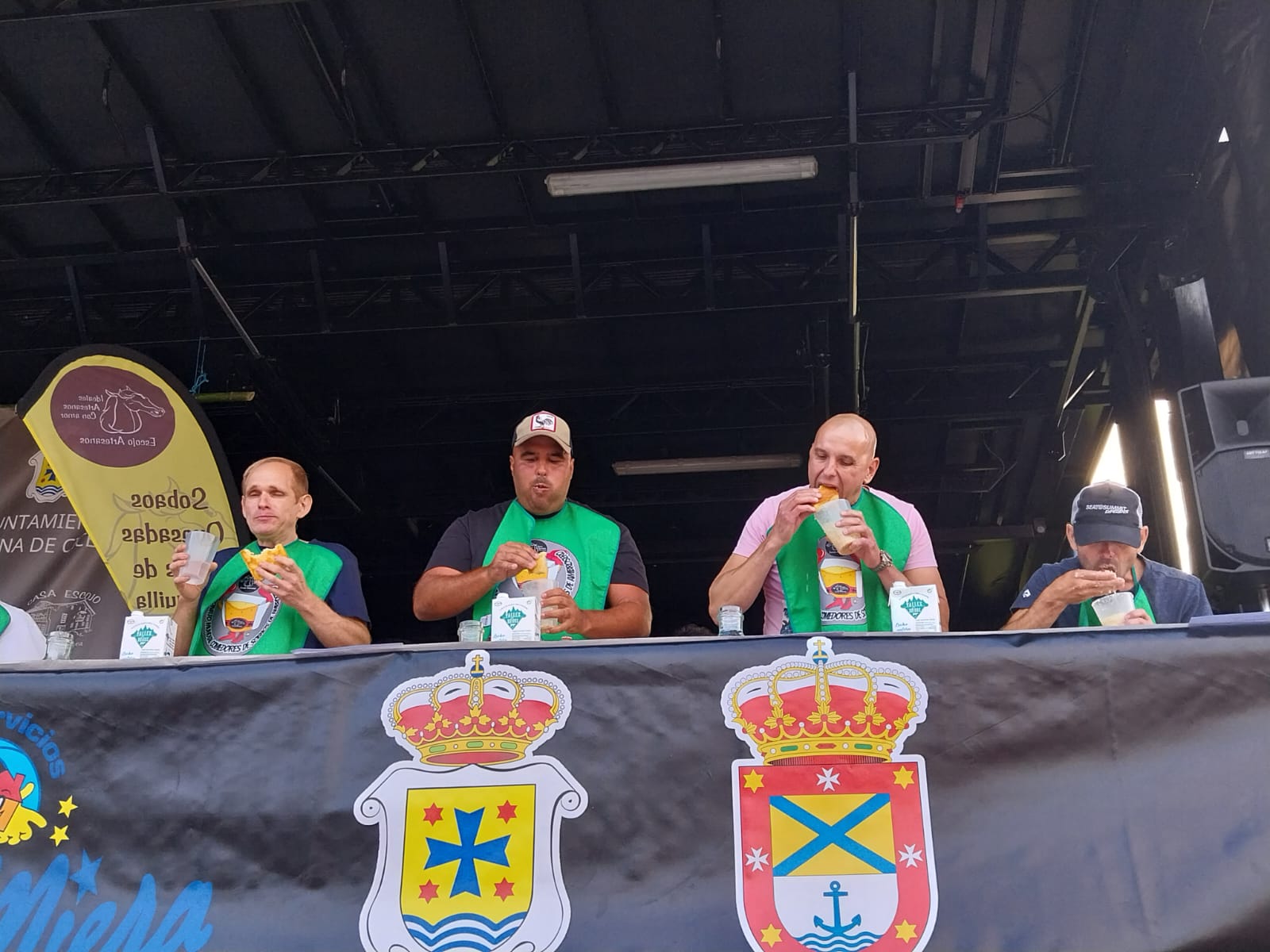 Varios de los participantes durante el concurso se comen los sobaos con la ayuda de un vaso de leche.