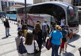 Usuarios de tren hacen cola para entrar en el autobús, frente a la estación, en una imagen de archivo.