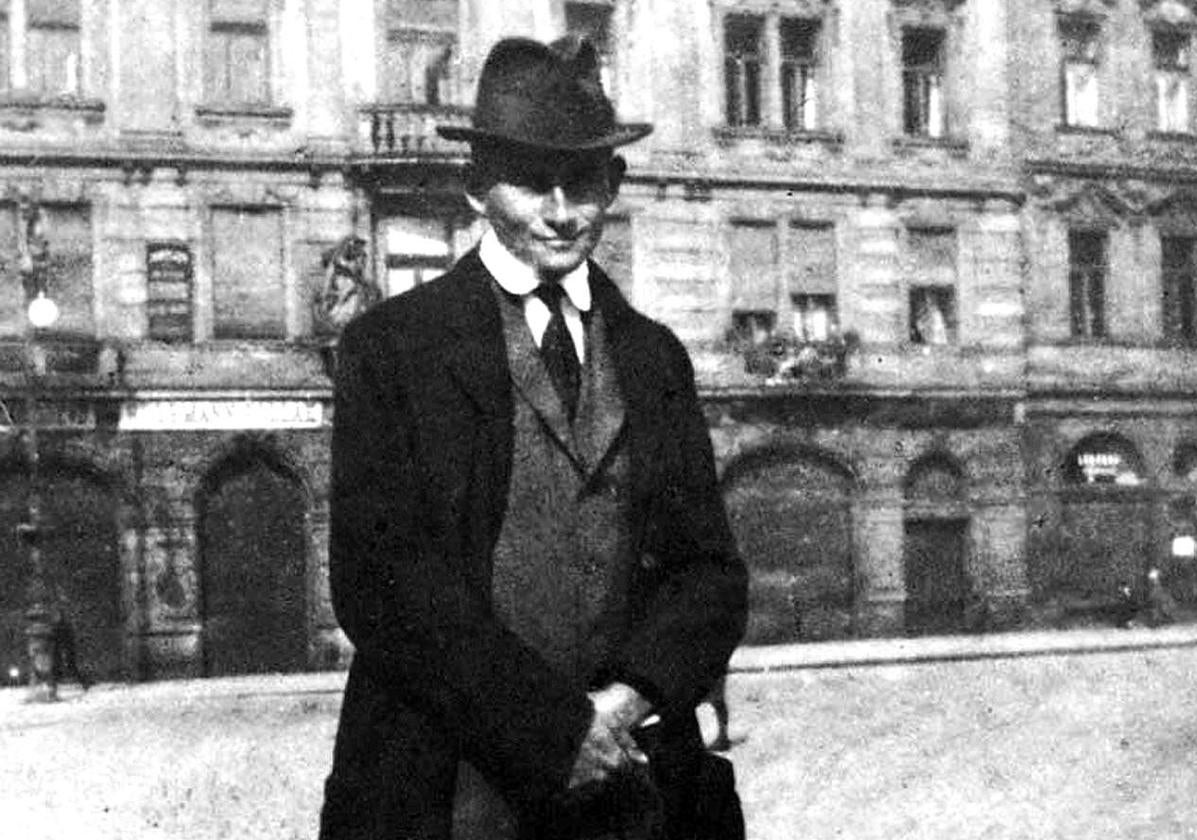 El escritor checo Frank Kafka posa ante el Kinsky Palace en la plaza de Praga.