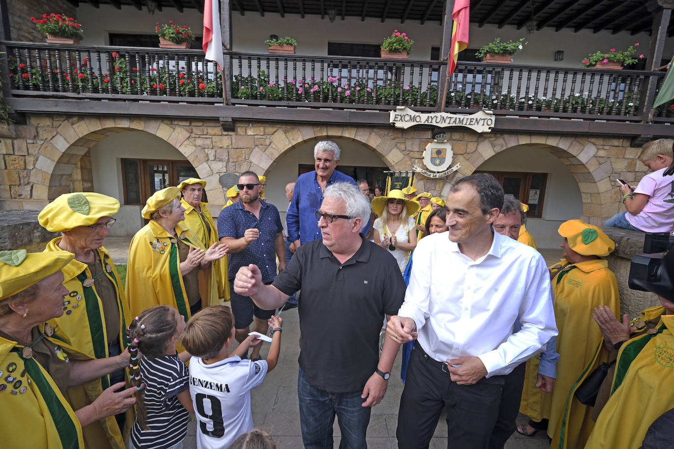 Leo Harlem saluda a unos niños y a los cofrades a la salida del Ayuntamiento, al fondo se ve a Romay.