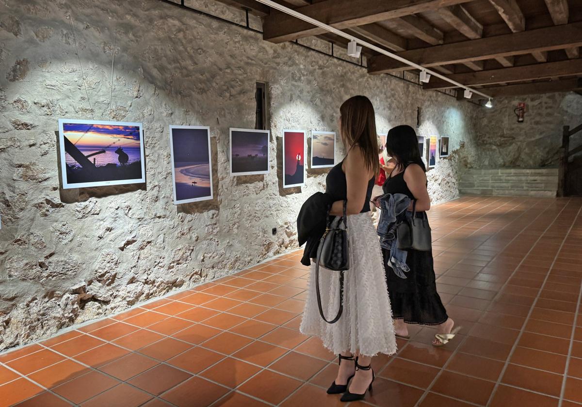 Dos mujeres observan la muestra 'Con pocas luces'.