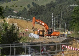 Una máquina excavadora carga tierra a un camión en las obras de duplicación de la línea férrea en Parbayón.