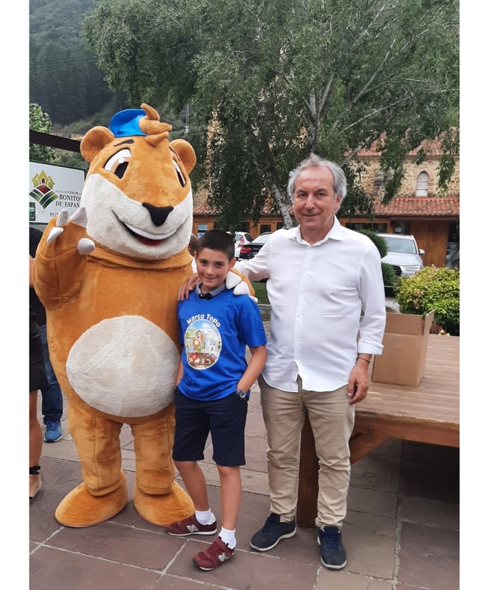 Imagen secundaria 2 - Dos momentos de la presentación del juego y el alcalde de Potes junto al niño ganador del concurso de la portada y la mascota del juego 