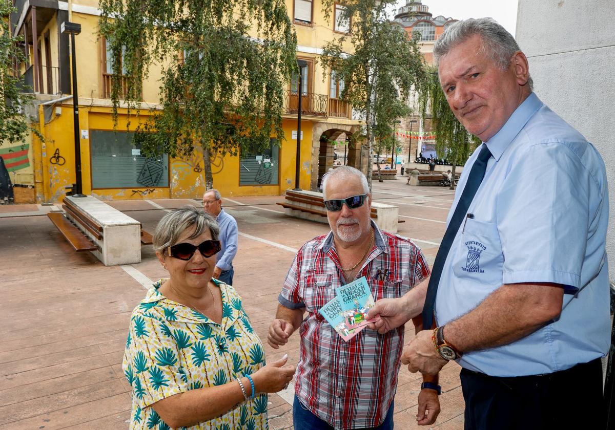 Vecinos reciben el programa en papel, ayer, en la plaza Baldomero Iglesias de Torrelavega