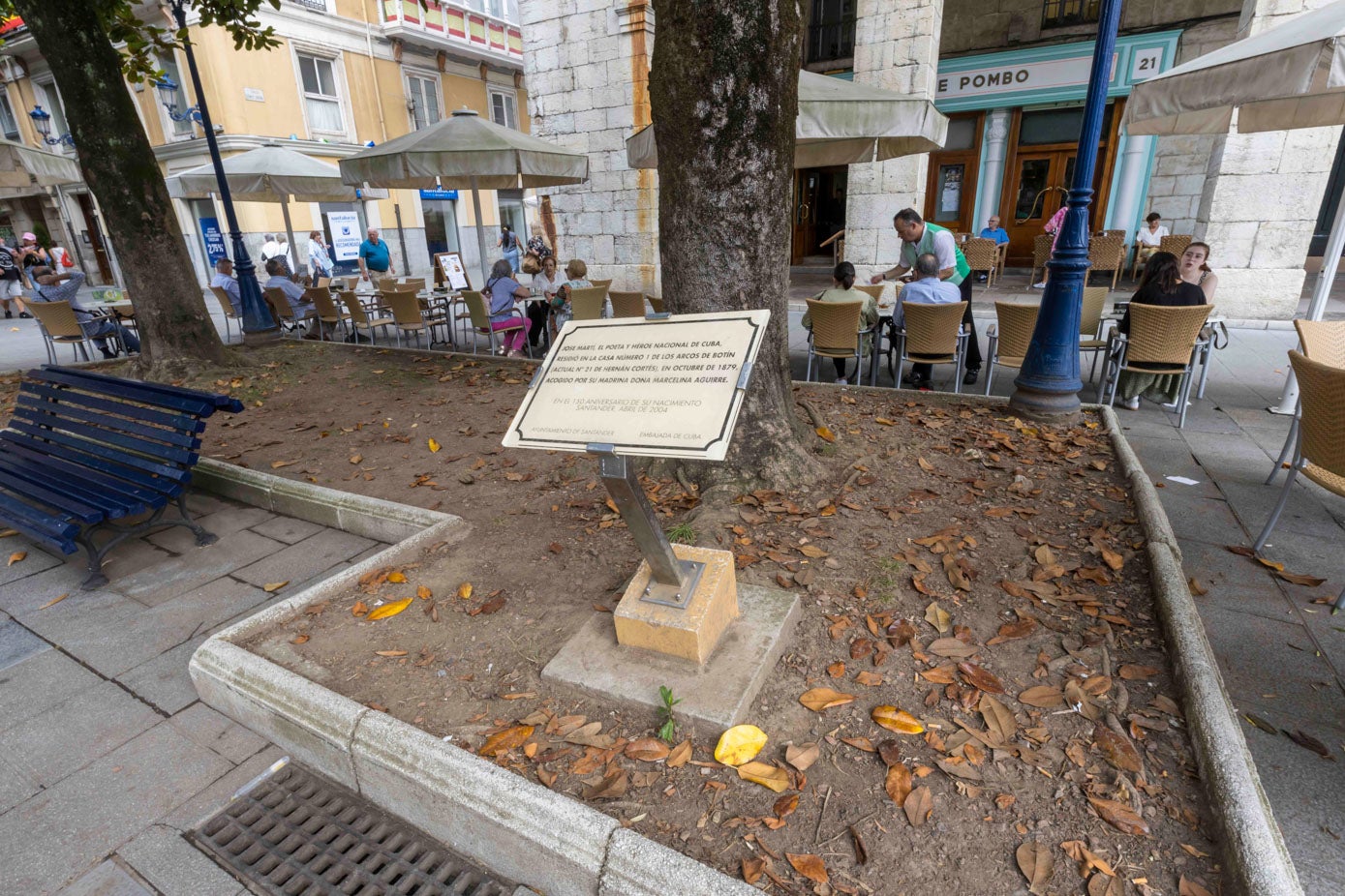 El parterre junto al Café de Pombo no tiene hierba, solo tierra y hojas secas de los árboles.