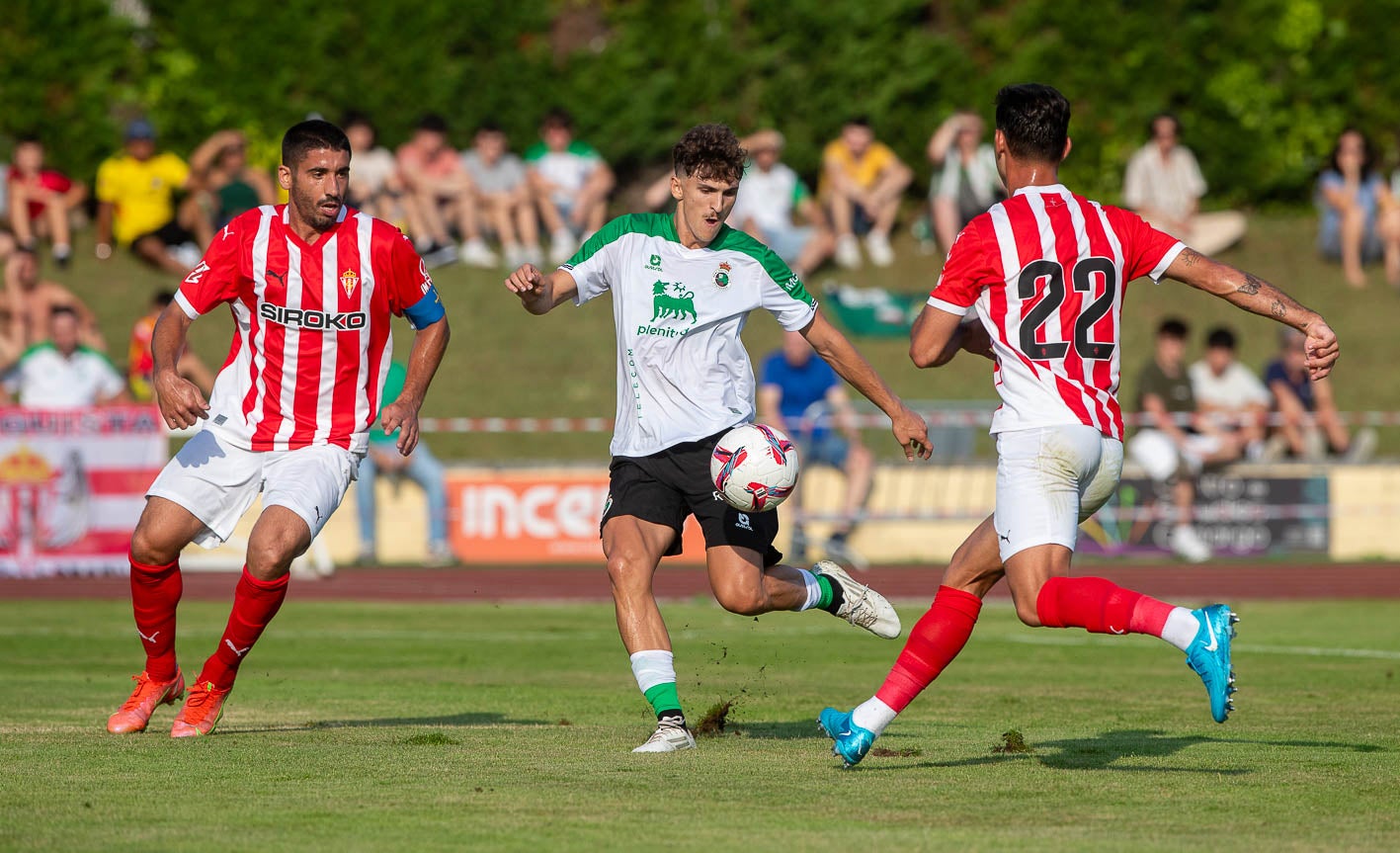 Pablo Rodríguez controla la pelota ante dos jugadores del Sporting, ayer en La Maruca