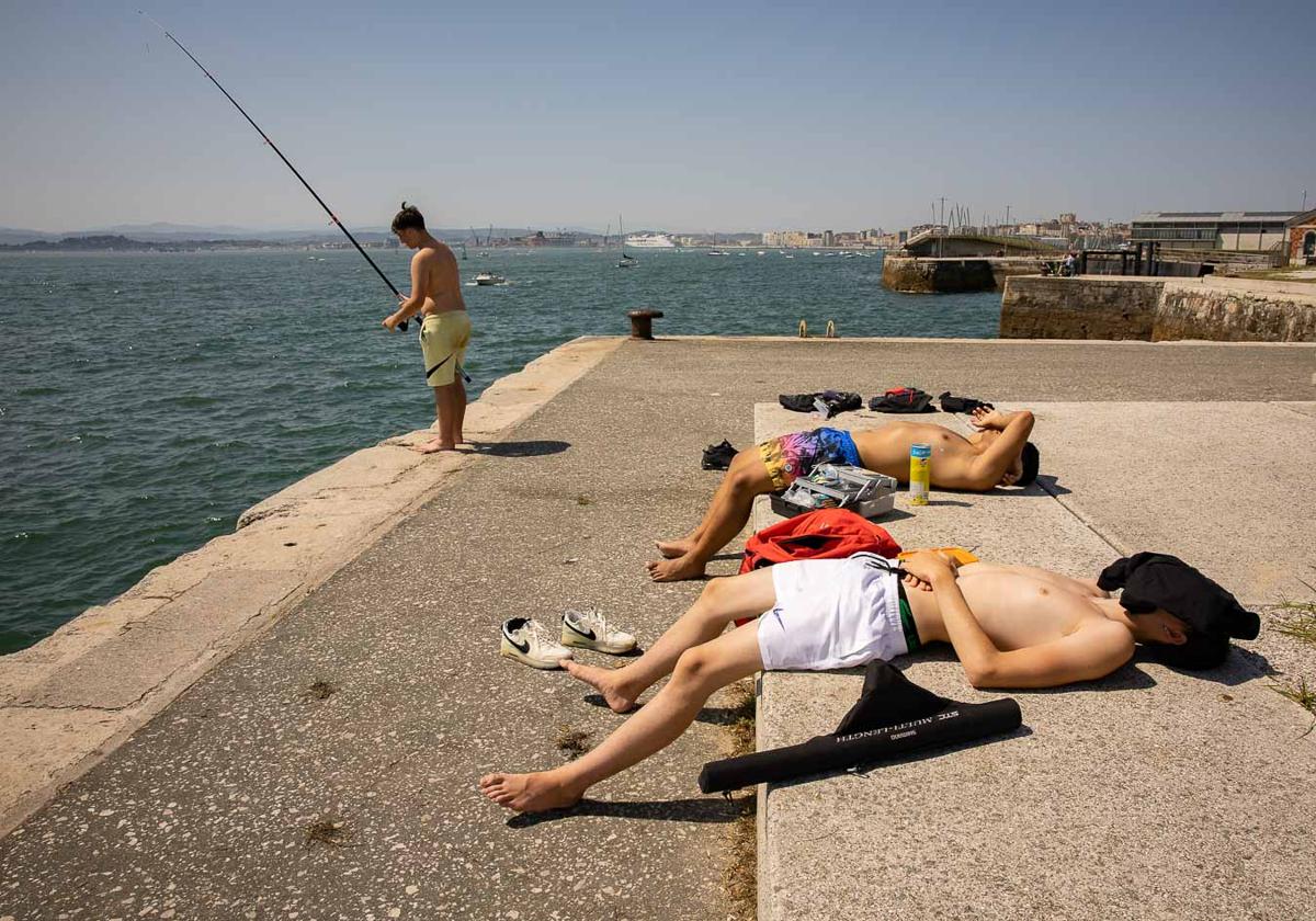 Pescando y descansando bajo el sol en Santander. Cubrirse la cabeza es una de las recomendaciones de las autoridades ante las altas temperaturas.