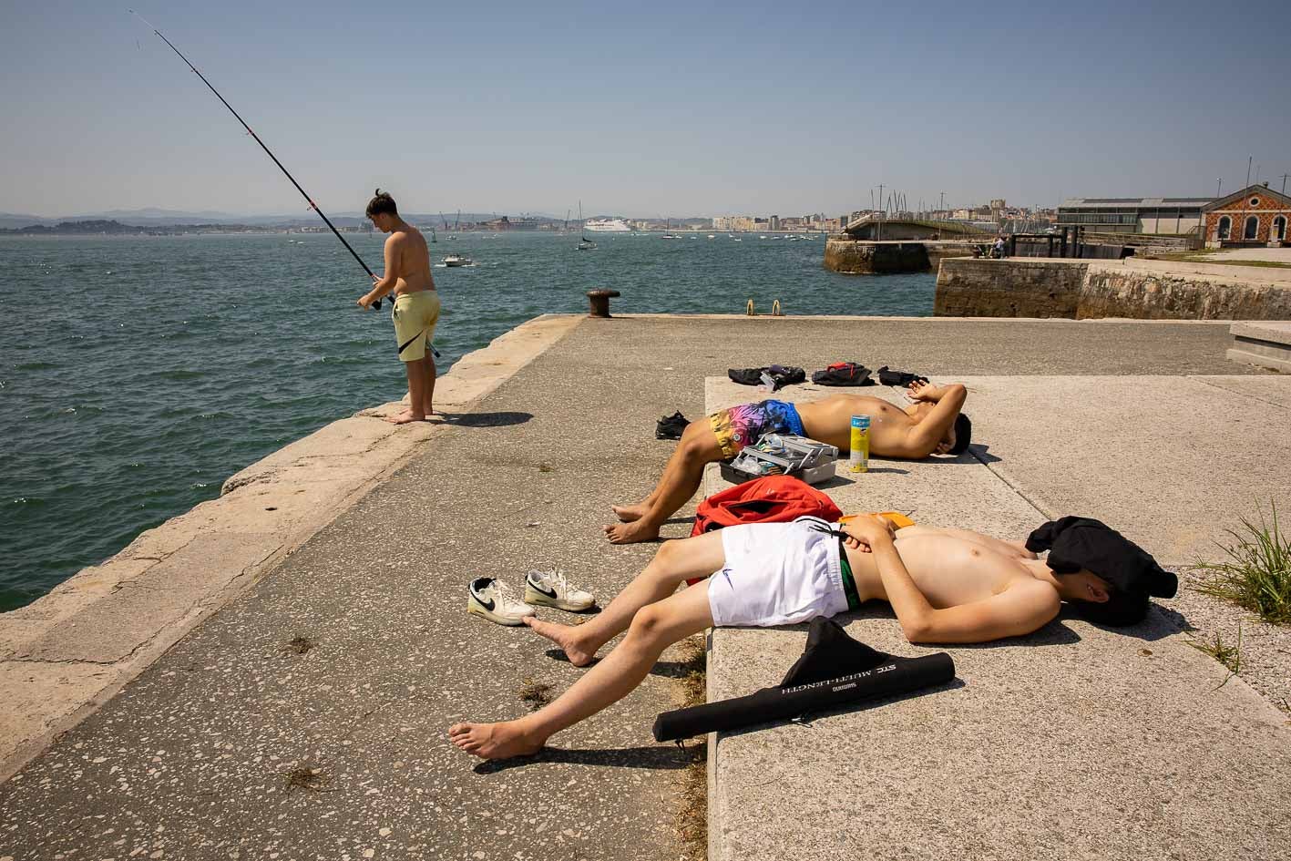 Pescando y descansando bajo el sol en Santander. Cubrirse la cabeza es una de las recomendaciones de las autoridades ante las altas temperaturas. 