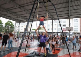 Uno de los monitores ayuda a una niña a realizar ejercicios en el trapecio.