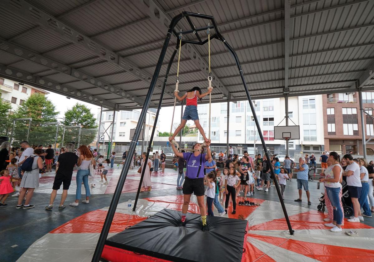 Uno de los monitores ayuda a una niña a realizar ejercicios en el trapecio.