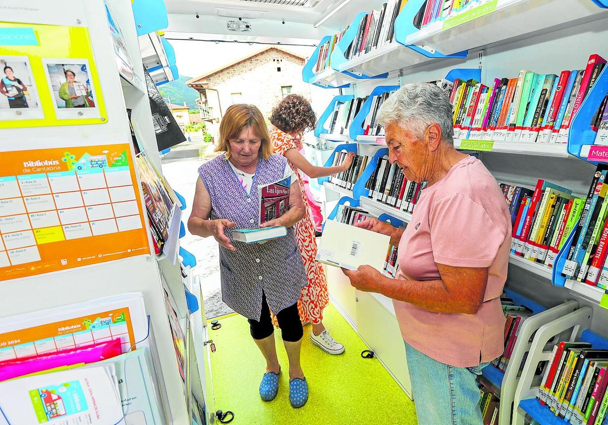 Las vecinas Carmen (izquierda) y Mari (derecha) escogen sus nuevas lecturas.