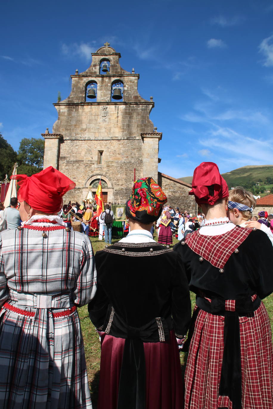 Tres mujeres con el santuario de Valvanuz ante ellas.